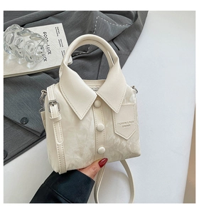 Detail of cream crossbody bag featuring unique shirt-inspired collar and button design