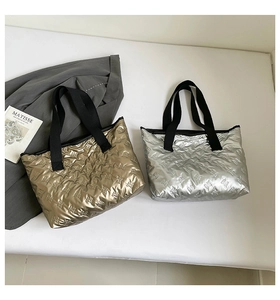 Detail of metallic quilted tote bags with bunny patterns in gold and silver finish