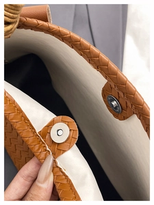 Detail of magnetic closure and woven texture on brown synthetic leather tote bag