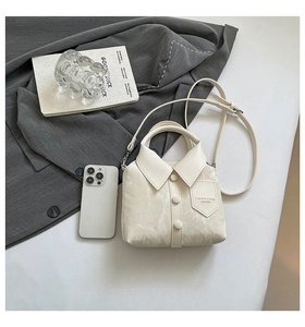 Detail of shirt-shaped crossbody bag featuring marble texture and fashion embossed text