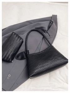 Detailed view of black woven leather handbag set with matching pouch and knotted handle