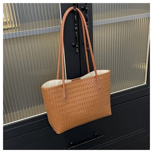 Detail der gewebten karamellfarbenen Ledertasche mit großer Struktur und schmalen Trägern