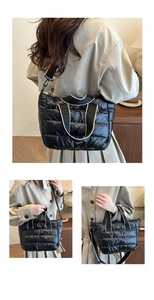 Detail showing the black quilted puffer tote bag with detachable crossbody strap and handles