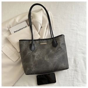 Vue à plat du sac cabas à motif marbre gris avec garniture dorée et anses noires chic