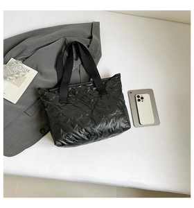 Close-up of black quilted tote bag with cute animal pattern and wide webbing handles