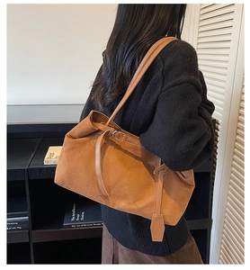 Detail of caramel suede tote bag with fine texture and stylish metal buckle strap