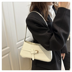 Dettaglio borsa baguette color crema con cinturino a fibbia in pelle liscia elegante