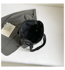 Detailed top view of a black quilted tote bag with spacious interior and inner zipper pocket