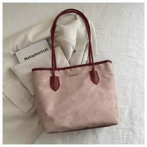 Détail du cabas vintage rose avec poignées rouge foncé et accent métallique doré