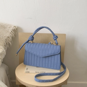 Light blue woven wheat pattern handbag with knotted handle and adjustable shoulder strap