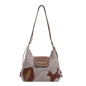 Borsa tote vintage in tela con finiture in pelle marrone e toppa cane Coole su fondo bianco