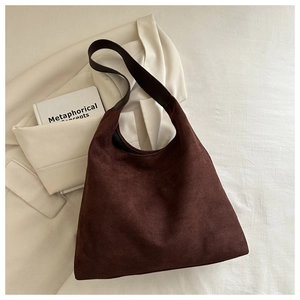 Close-up of deep brown suede hobo bag with wide shoulder strap and matte texture