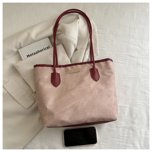 Détail d'un grand sac fourre-tout rose avec bordure en cuir rouge et métal