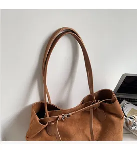 Macro shot of durable handles and stitching on this brown suede tote bag for women