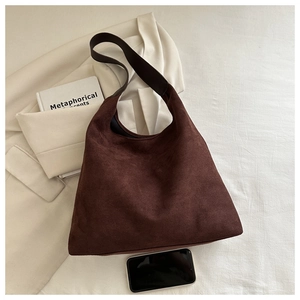 Detail of dark brown suede hobo bag with wide shoulder strap and spacious interior