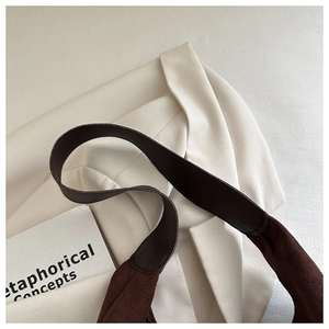 Close-up of a dark brown tote bag showing the high-quality leather and suede material mix