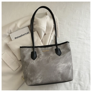 Détail du grand sac cabas gris foncé avec texture marbrée et plaque dorée chic