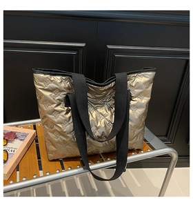 Detailed macro view of champagne gold quilted tote bag with embossed bow patterns
