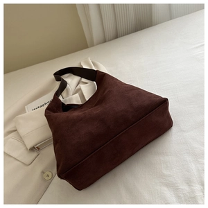 Detailed view of deep brown suede tote bag with soft texture and wide shoulder strap