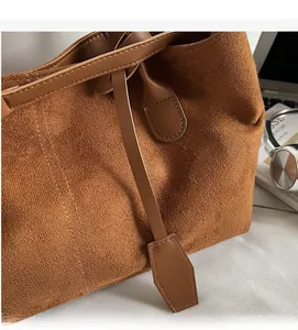 Detail of brown faux suede tote bag featuring leather drawstring and retro matte finish
