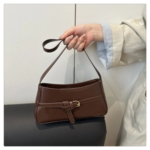 Close-up of a brown baguette underarm bag featuring a stylish golden square buckle detail