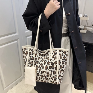 Large leopard print tote bag with white leather handles and matching coin purse on a model