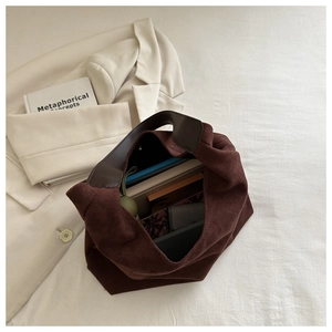 Top-down view of large brown suede tote bag with books showing interior storage capacity