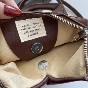 Dark brown textured crossbody bag featuring internal magnetic clasp and casual pouch label
