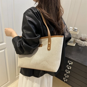 Minimalist beige canvas tote bag with brown leather handles and large capacity