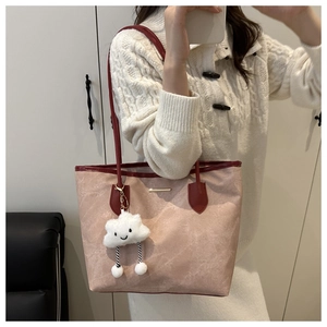 Close-up of a pink tote bag with dark red trim and a cute cloud plush charm detail