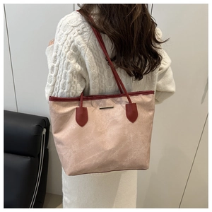 Détail du grand sac cabas abricot en suédine avec bandoulières contrastées bordeaux