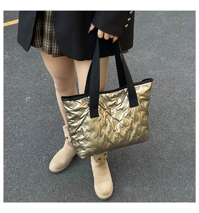 Detail of silver metallic quilted tote bag featuring stylish 3D bow patterns and black straps