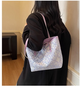 Detail of purple geometric textured tote bag with silver studs on leather strap