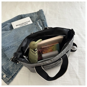 Detail view of silver quilted tote bag showing large capacity and contrast canvas straps