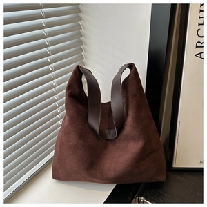 Detail showing the brown suede texture and leather handle of a large tote bag