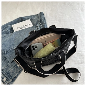 Detail showing the internal storage capacity of the black quilted tote bag for daily use