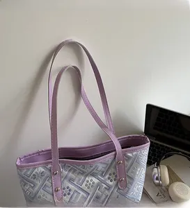 Detail of purple jacquard tote bag featuring slim straps and silver metal rivets