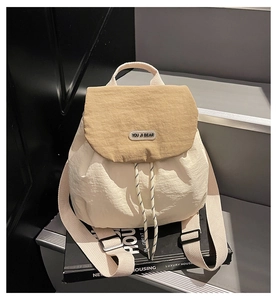 Detail of beige nylon backpack with khaki flap and adjustable drawstring closure