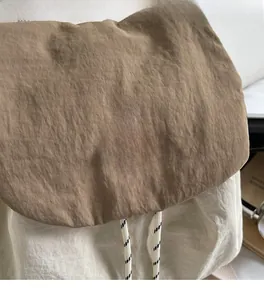 Detailed macro view of the textured nylon fabric and YOU JI BEAR logo on the casual backpack