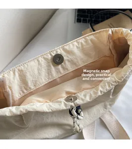 Detail of beige nylon backpack with magnetic snap closure and polka dot drawstring