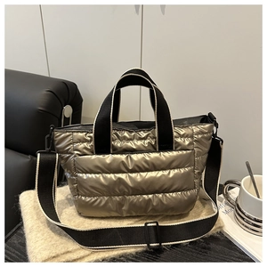 Close-up of champagne gold quilted puffer tote bag with adjustable canvas shoulder strap