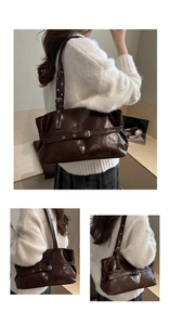 Detailed view of dark brown glossy leather tote bag with stylish buckle and adjustable strap