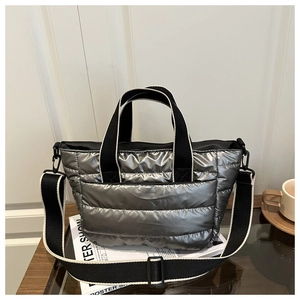 Close-up of metallic silver quilted puffer tote bag with contrast wide woven handles