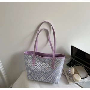 Detail of purple plaid tote bag showing jacquard texture and leather rivet handles