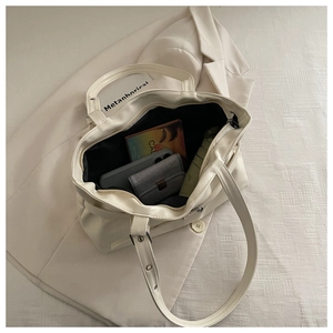 Internal view showing large capacity and zipper closure of this cream tote bag