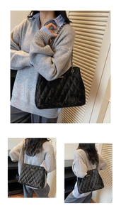 Détail du sac cabas matelassé noir avec logo doré et bandoulière en chaîne tressée