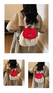 Detailed view of the red flap closure and brand logo on women's nylon backpack