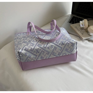 Detailed view of the purple floral embroidered tote with premium faux leather stitching
