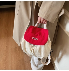 Detail of red and cream drawstring bag with YOU JI BEAR logo and woven cord closure