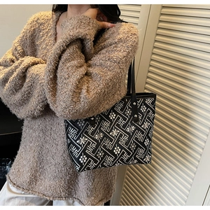 Ethnic pattern tote bag detail on shoulder of model wearing a brown knit sweater